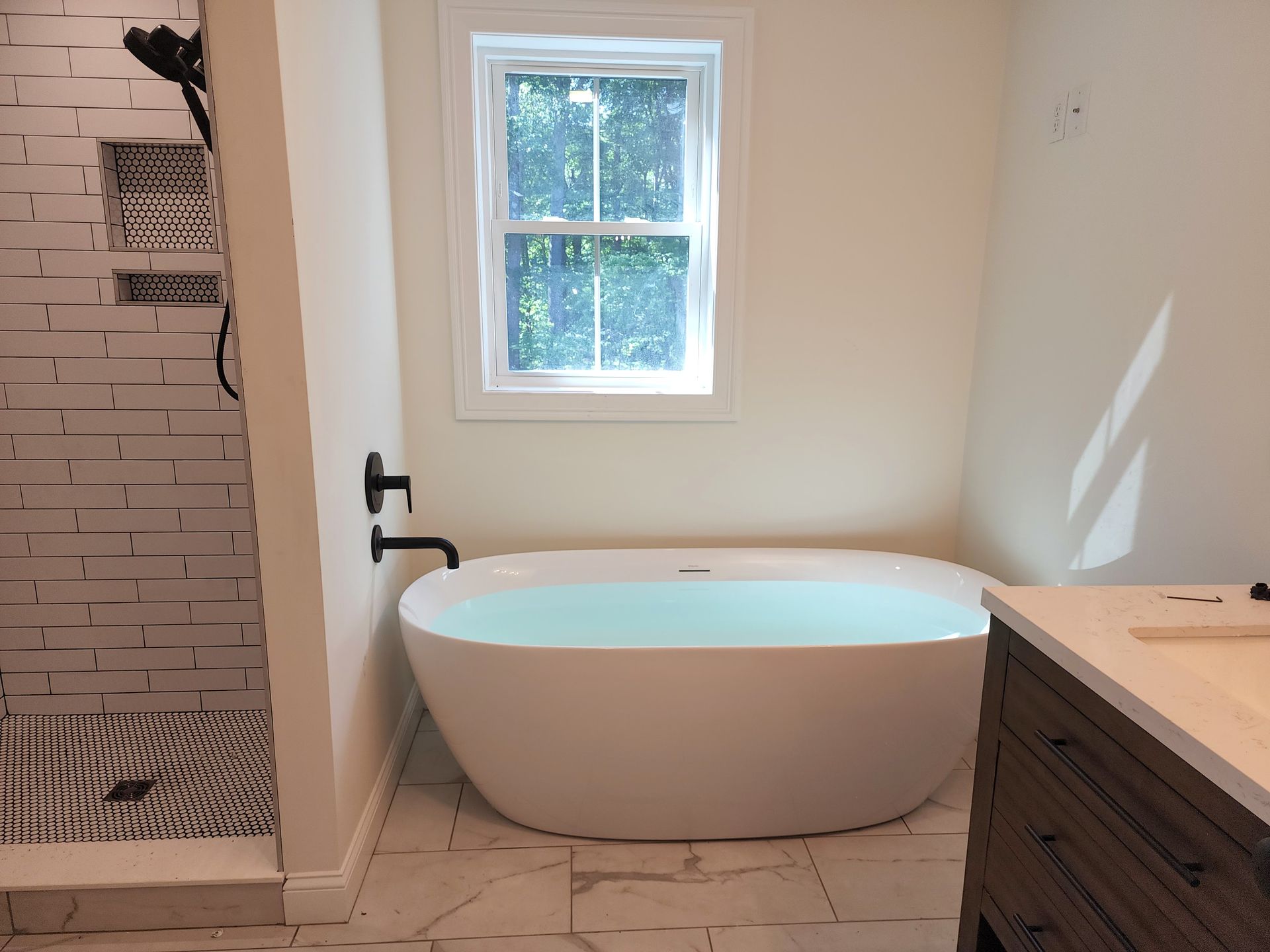 A bathroom with a bathtub and a window