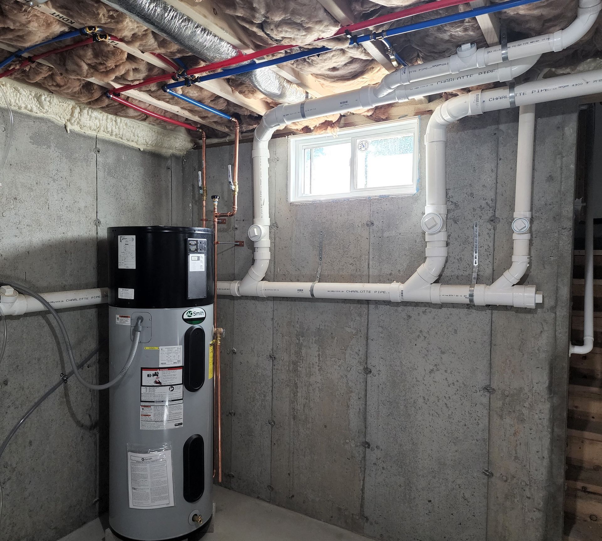 A basement with a water heater and pipes