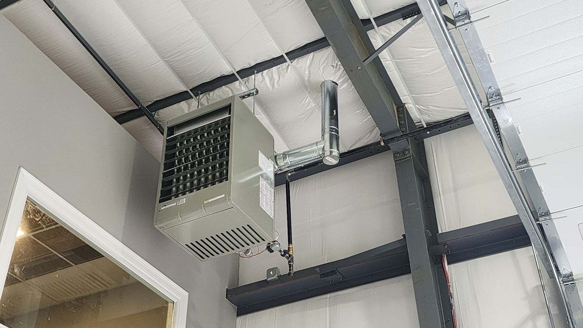 A heater is hanging from the ceiling of a building.