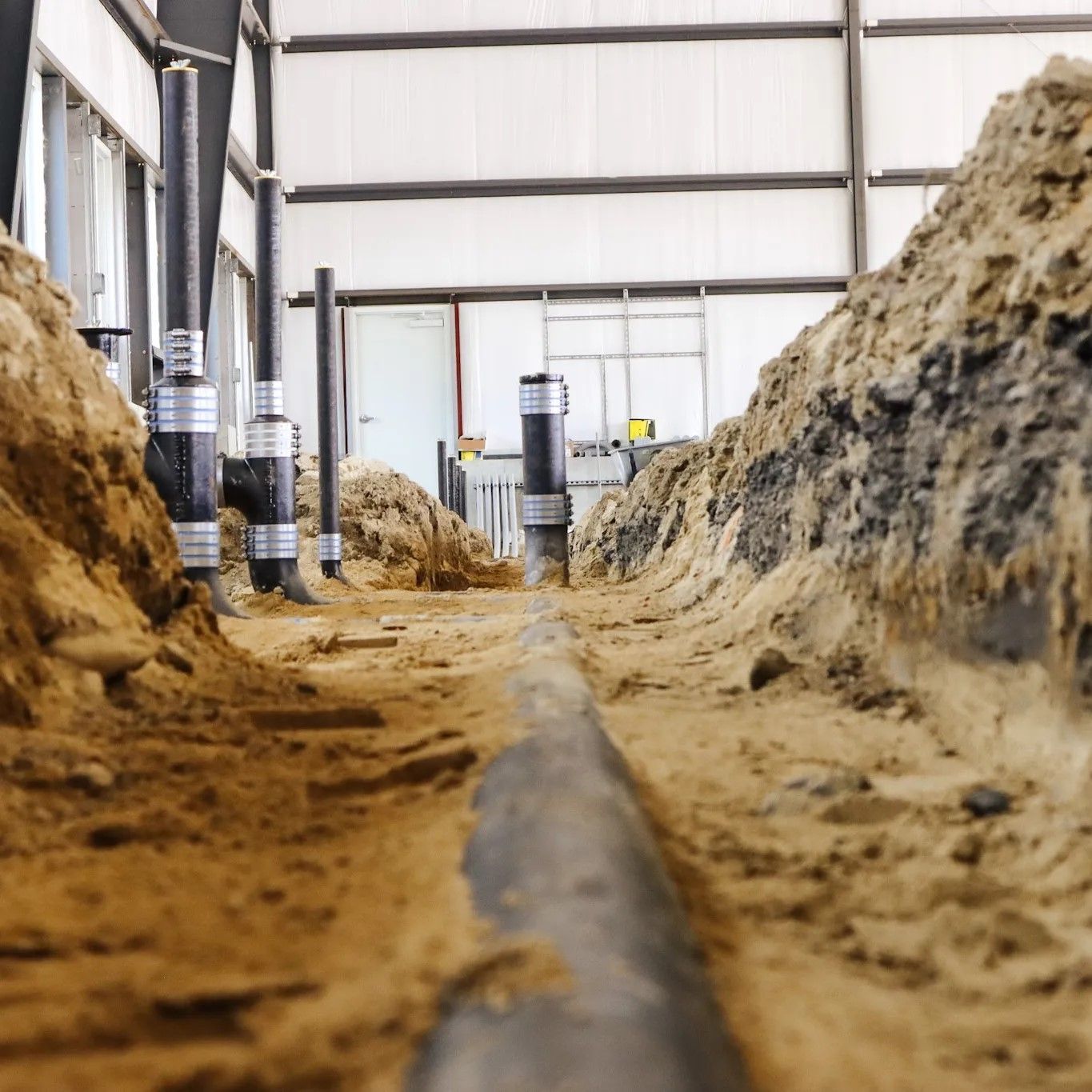 A large pile of dirt and pipes in a building