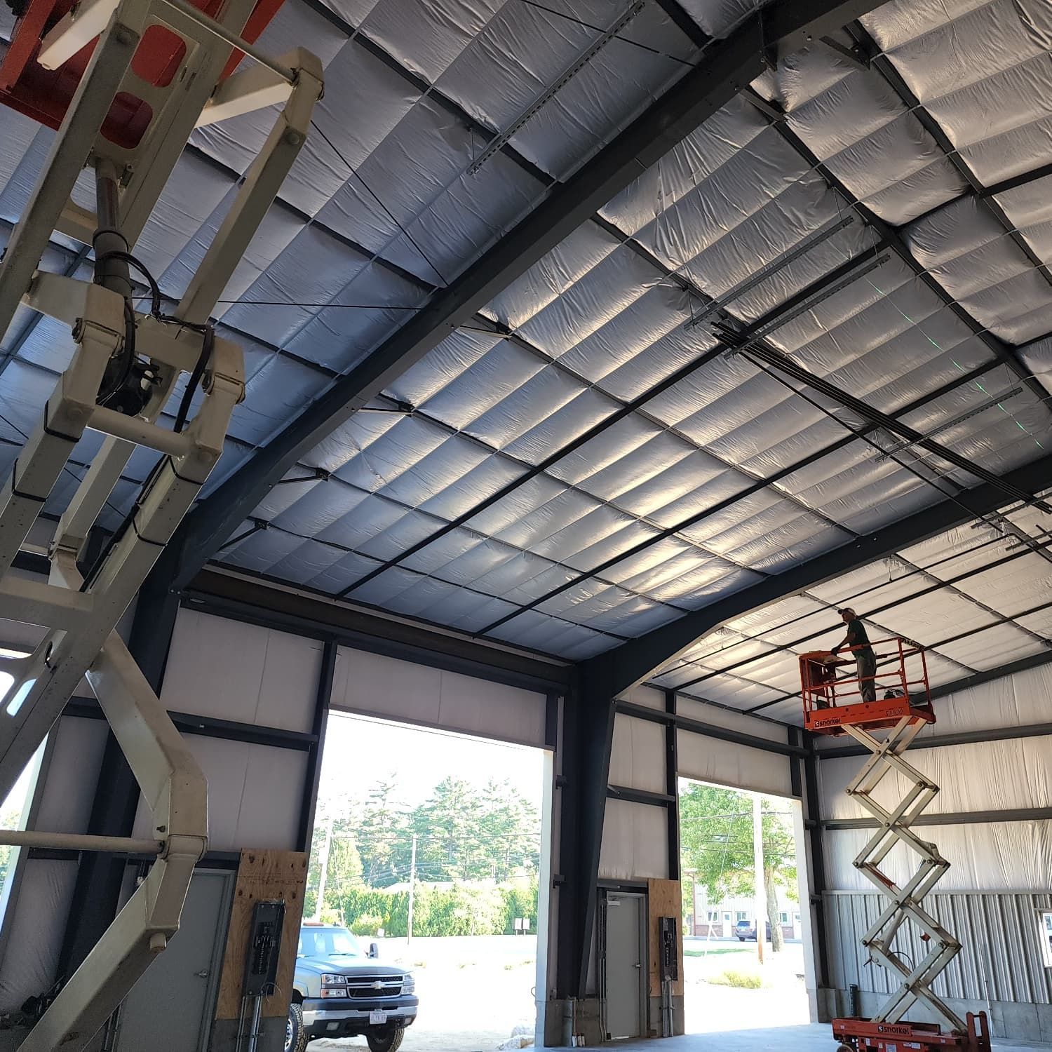 A man on a scissor lift in a large building