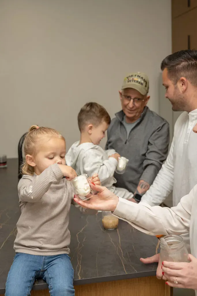 Children and adults sharing drinks around a table at a casual indoor gathering