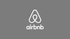 Airbnb logo in white on a gray background