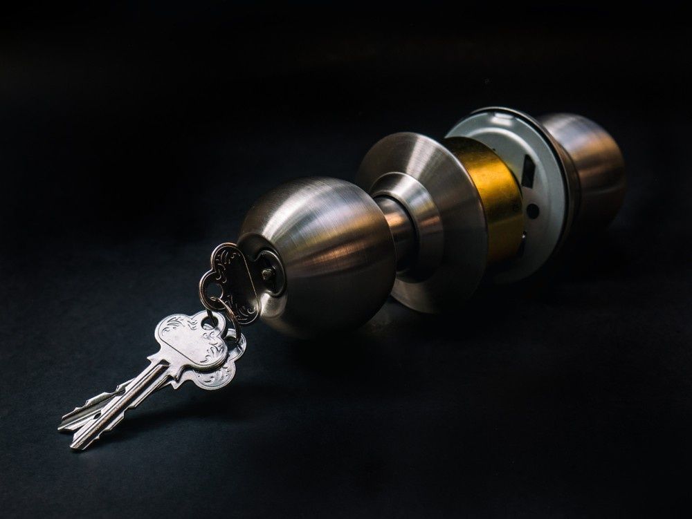 Silver Doorknob with Keys Inserted, on A Black Surface — NORTHCOAST LOCKSMITHS & SECURITY In Wingham, NSW