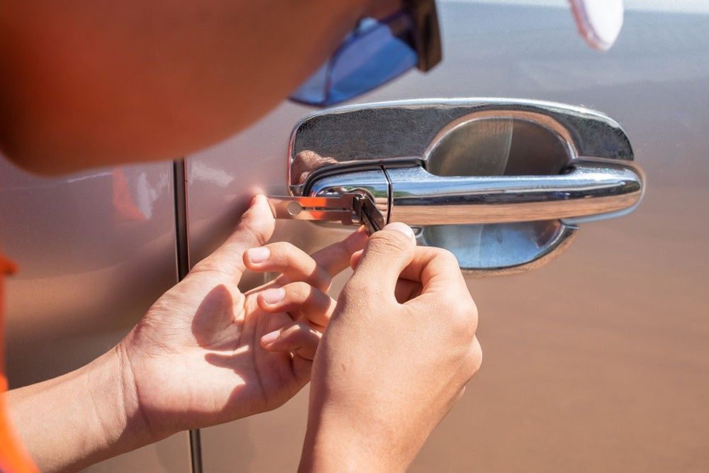 Person Using a Tool to Unlock a Car Door — NORTHCOAST LOCKSMITHS & SECURITY In Harrington, NSW
