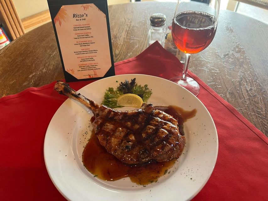 A plate of food and a glass of wine on a table.