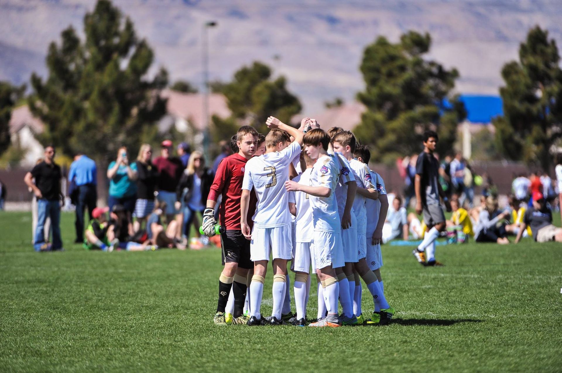 Team Challenger FC team huddled on a field