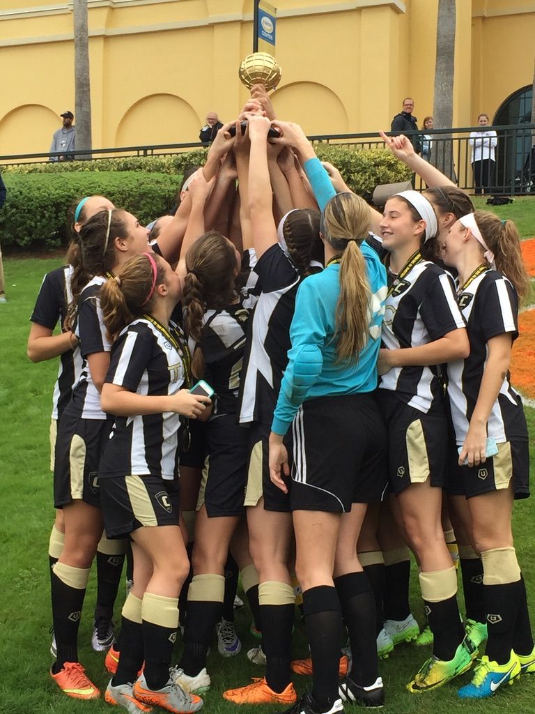 Team Challenger FC team lifting a trophy in celebration on the field