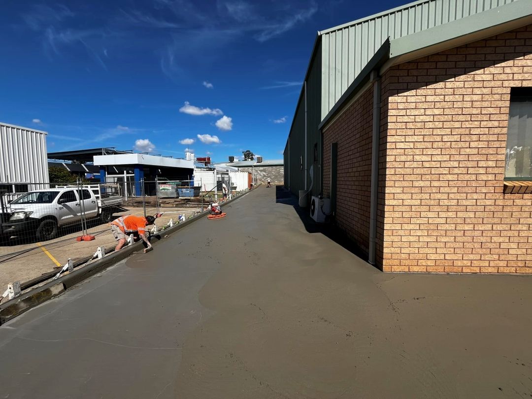A Man is Working on a Concrete Driveway — All Aspects Concreting & Earthworks Pty Ltd in Orange, NSW