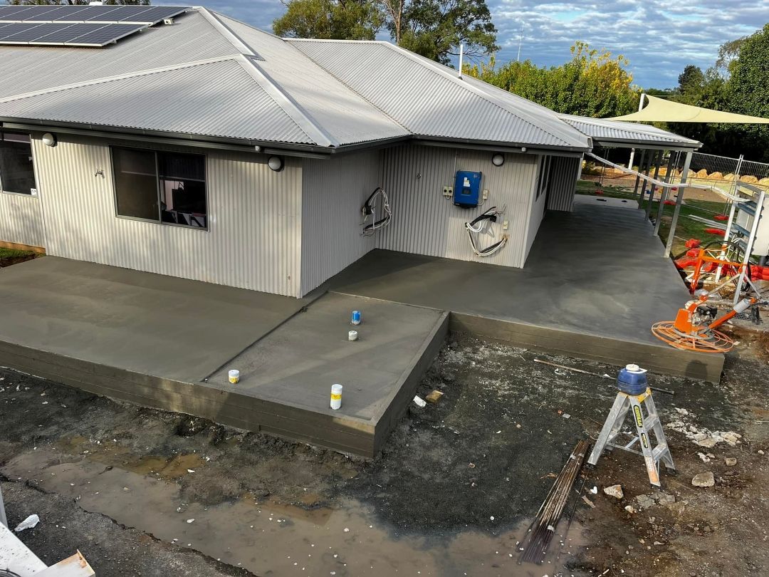 House is Being Built With a Concrete Driveway in Front of It — All Aspects Concreting & Earthworks Pty Ltd in Singleton, NSW