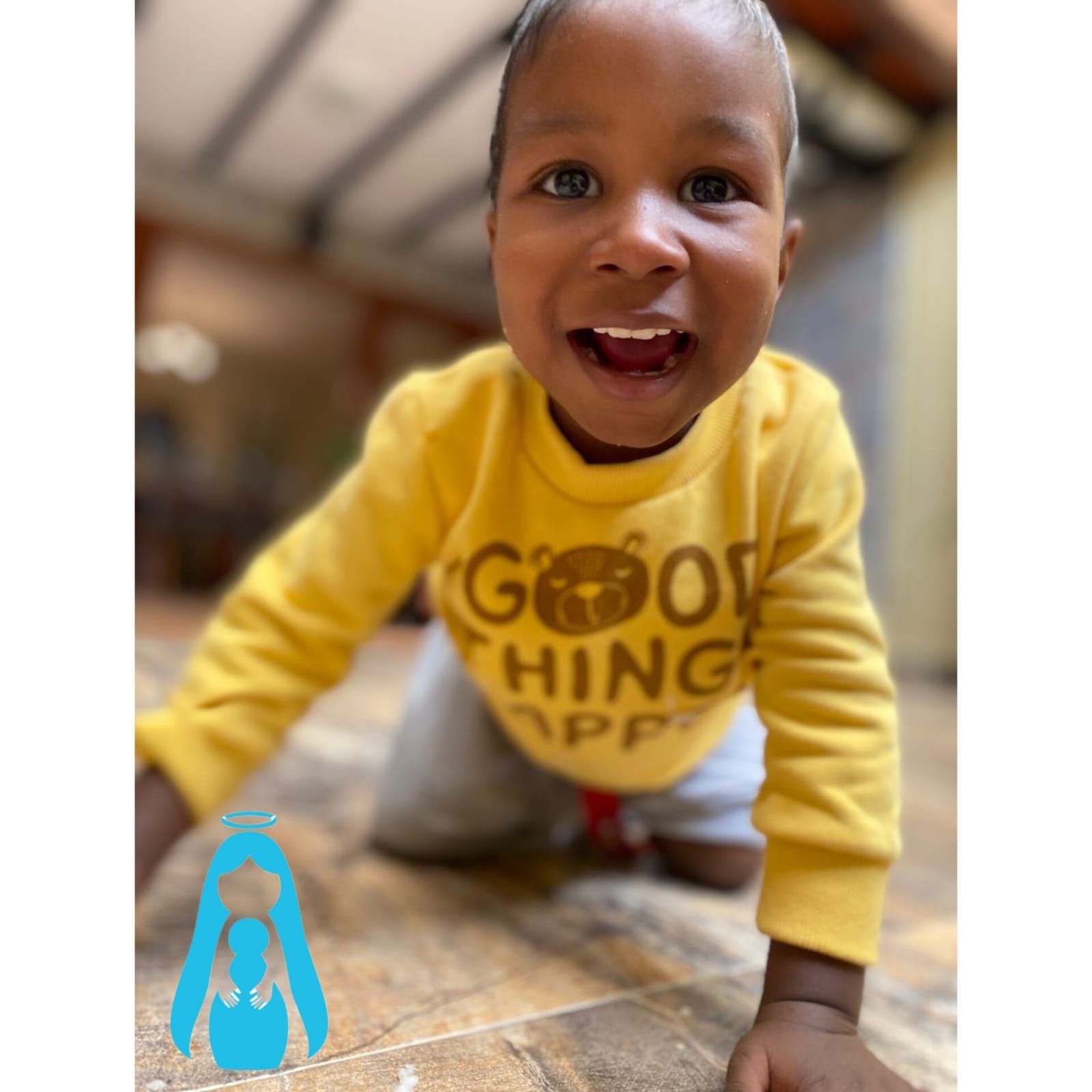 Un niño sonriente que viste una sudadera amarilla con la frase
