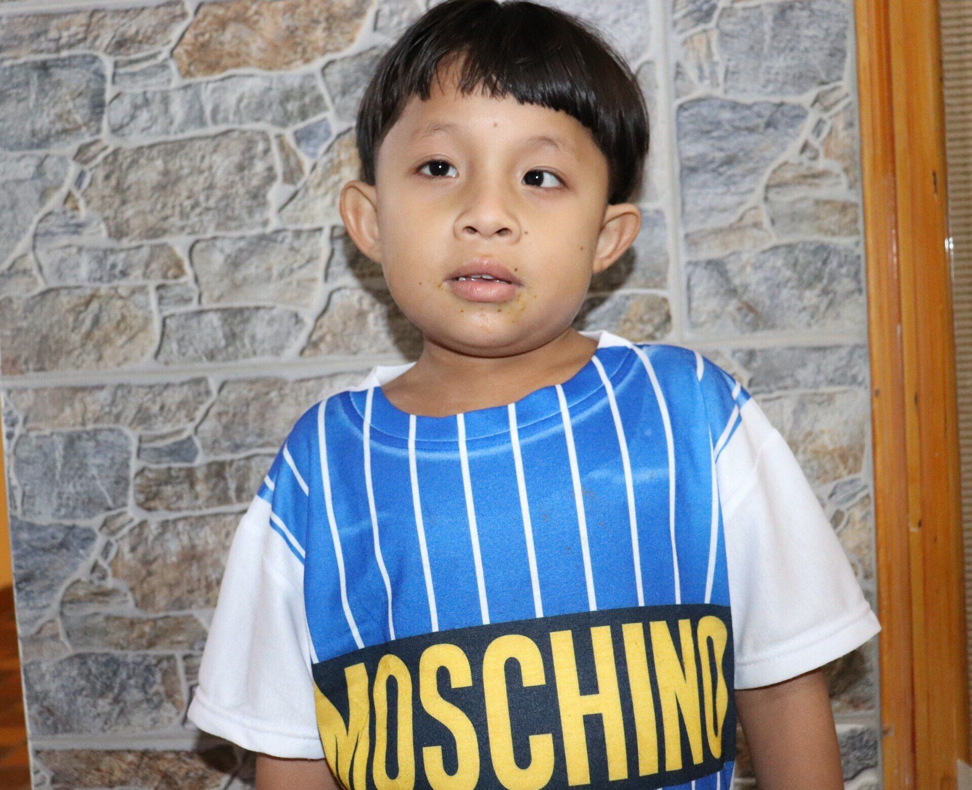 Niño con una camiseta azul y blanca con la palabra 