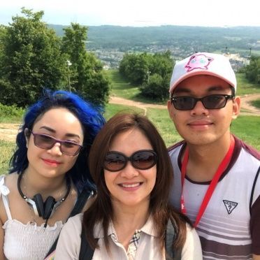 A man and two women wearing sunglasses pose for a picture