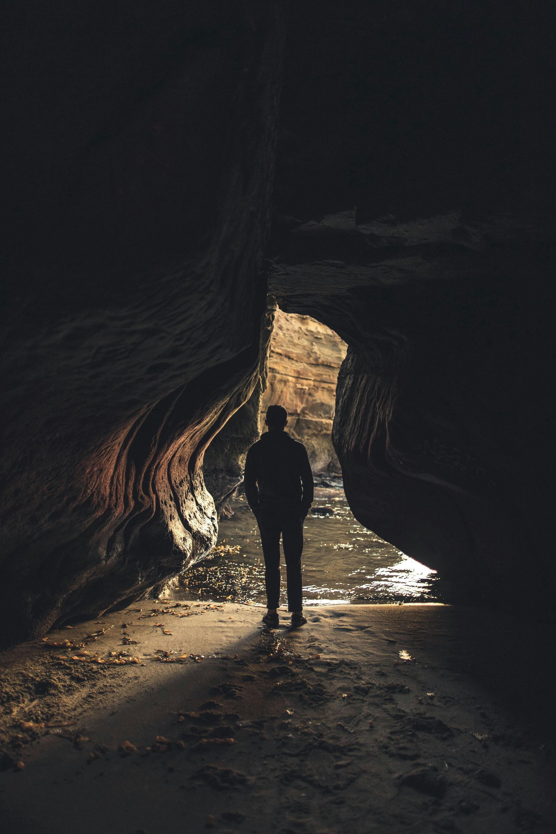A person is standing in the middle of a cave.