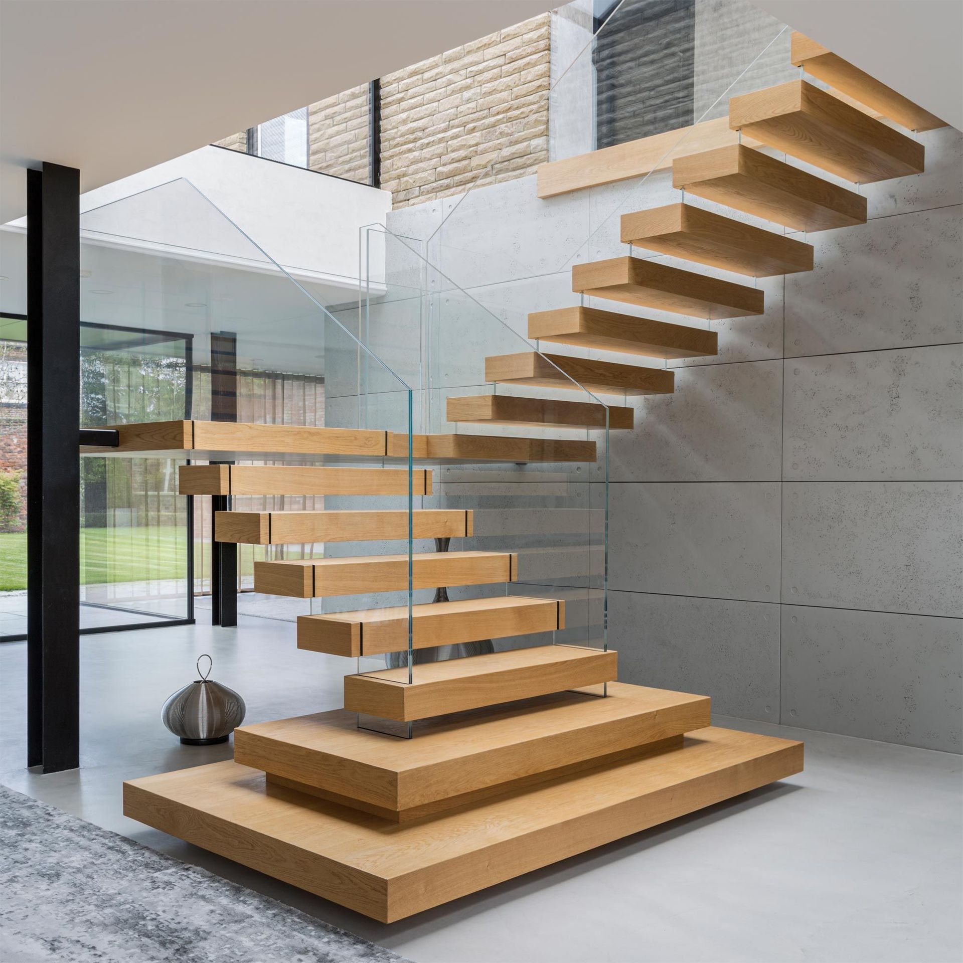 Modern floating wooden staircase with glass railings in a bright contemporary interior