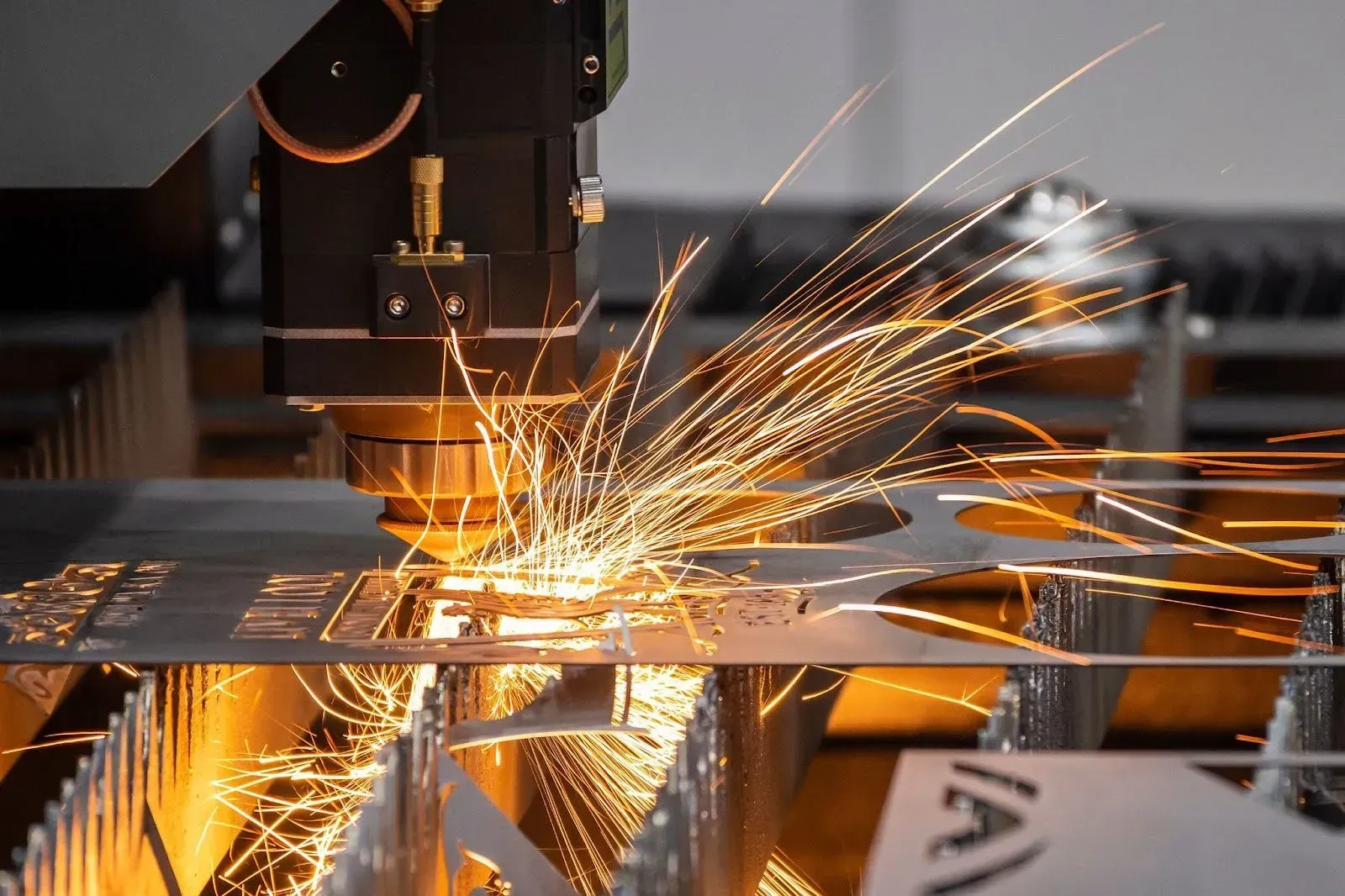 CNC machine cutting metal plate with bright sparks flying in an industrial workshop