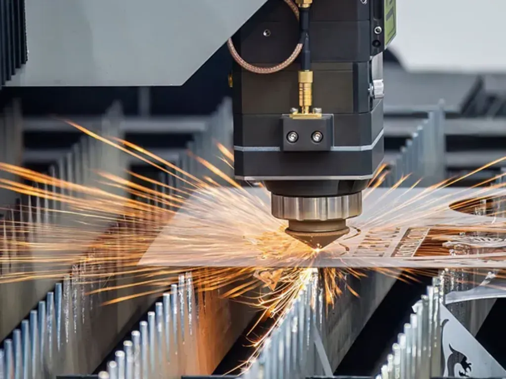 Laser cutting metal, sparks flying from a CNC machine over a ribbed steel sheet