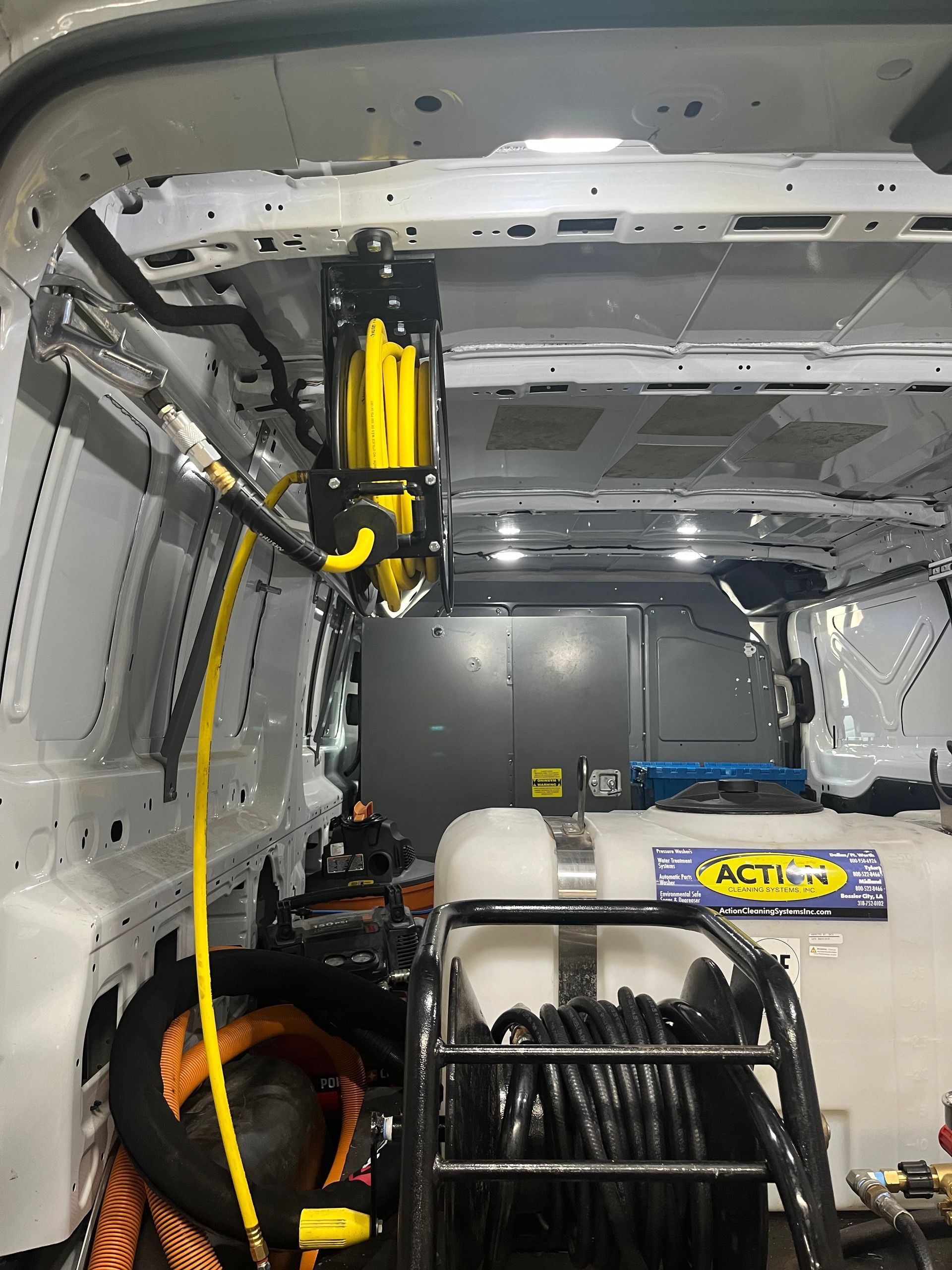 The inside of a van with a hose hanging from the ceiling.