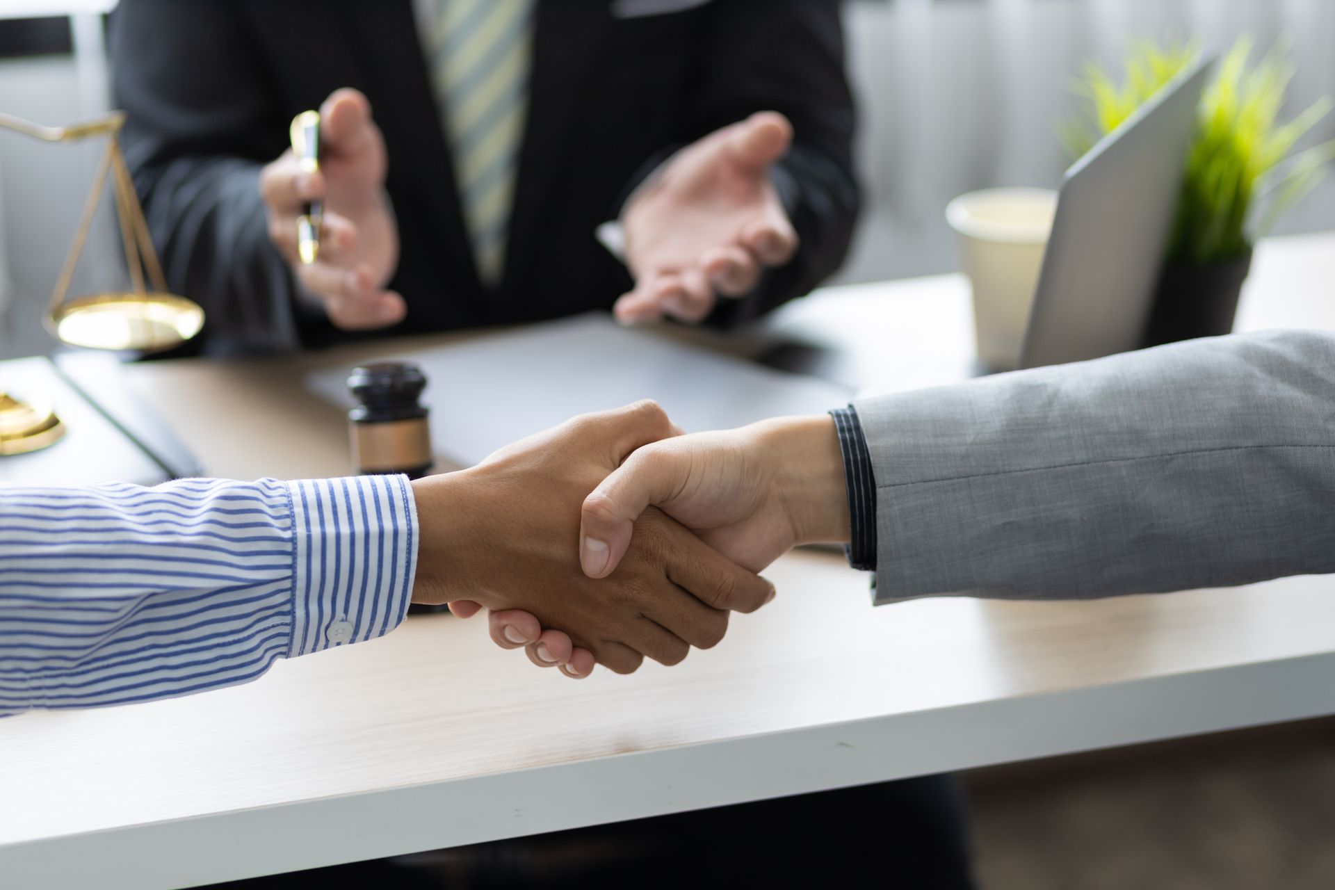 a man and a woman are shaking hands in front of a lawyer .