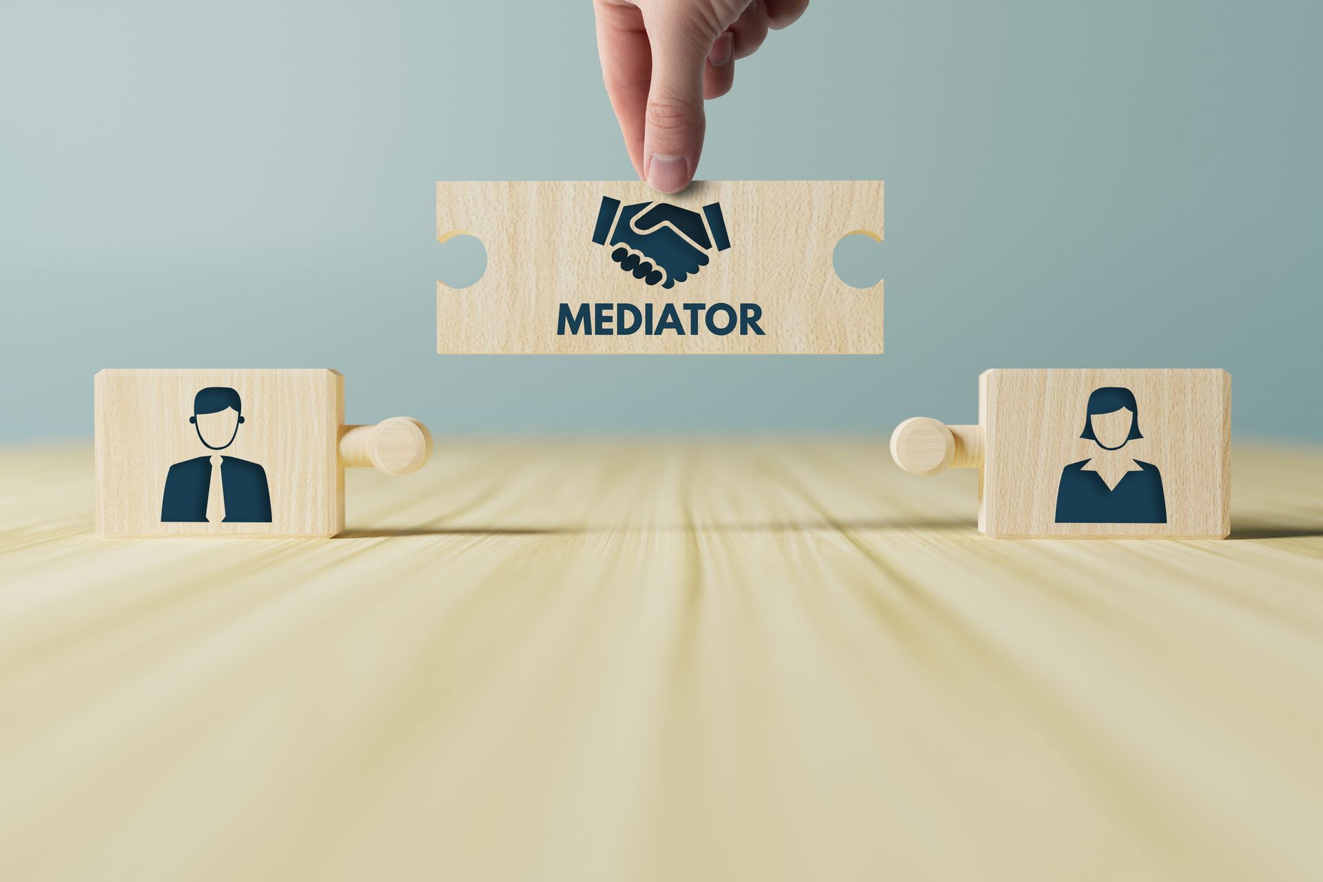 a person is holding a wooden puzzle piece with a handshake between two people .