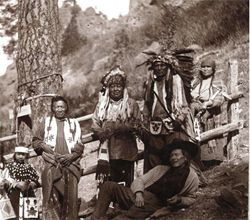 A group of native americans are posing for a picture in a black and white photo.