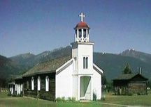 A small white church with a cross on top of it.