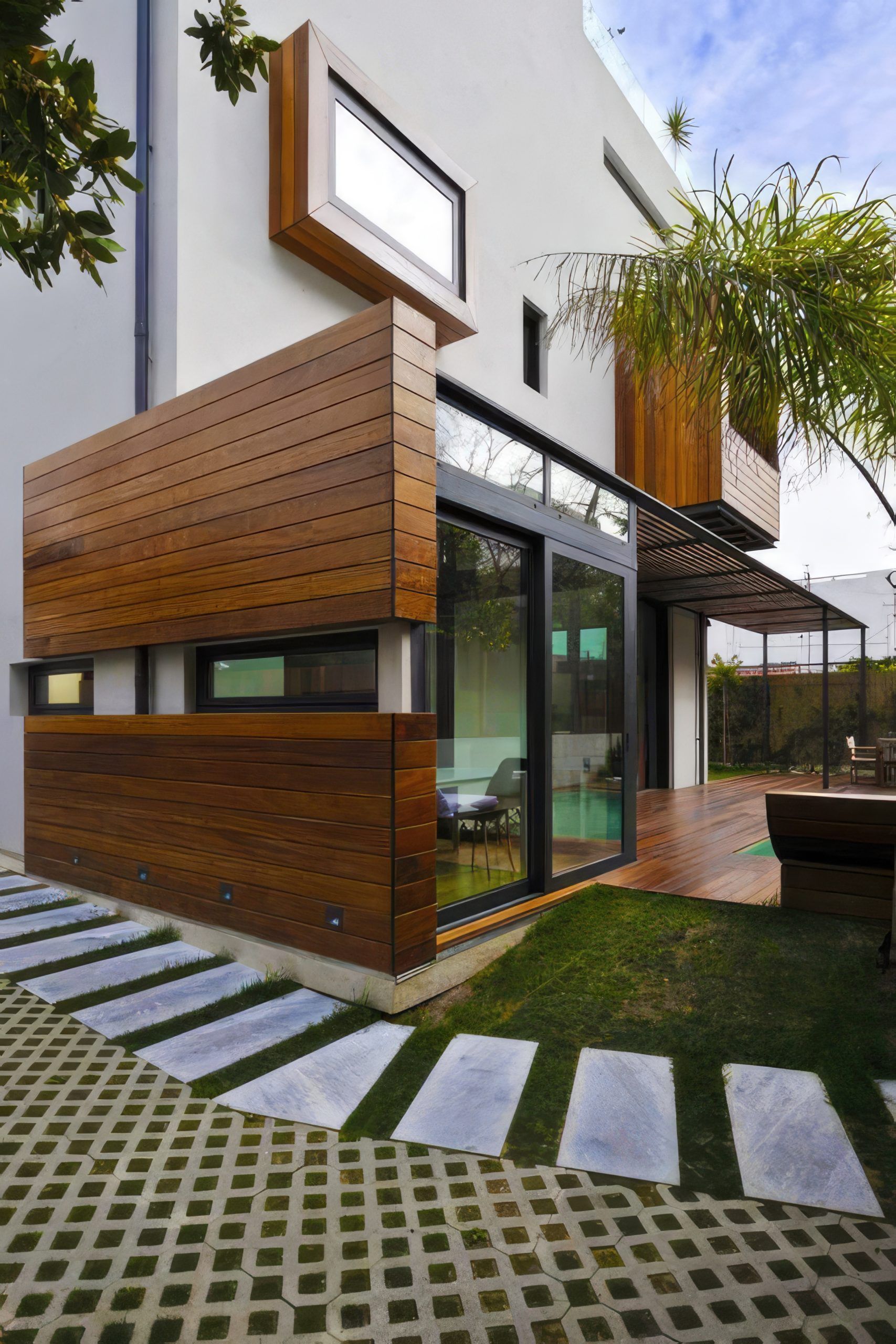 Covered outdoor corridor with wooden ceiling, stone floor, and seating along glass-fronted building