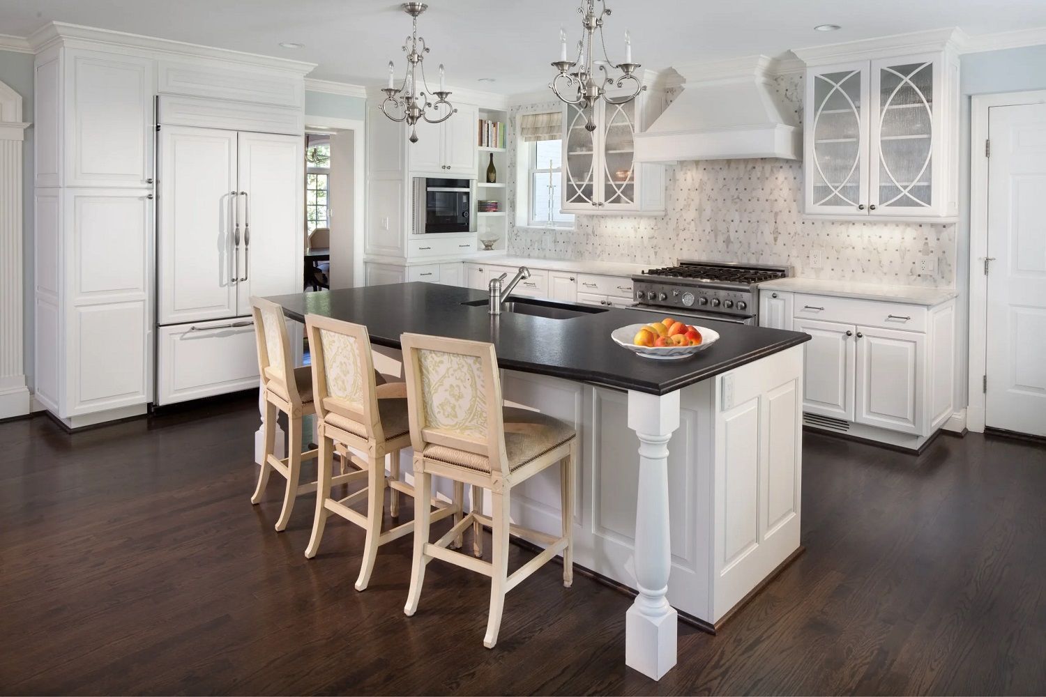 Bright modern white kitchen with island, bar stools, dark wood floor, and stainless steel appliances