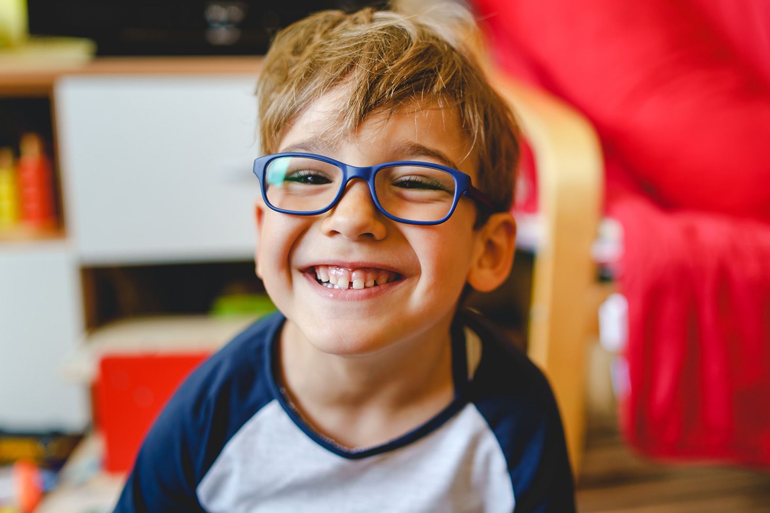 Smiling child wearing blue frame eyeglasses Smiling child wearing blue frame eyeglasses