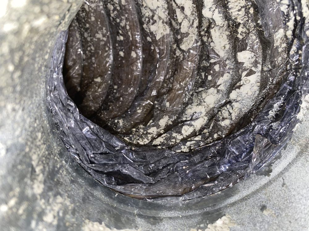 A close up of a dirty duct with a lot of dust on it.
