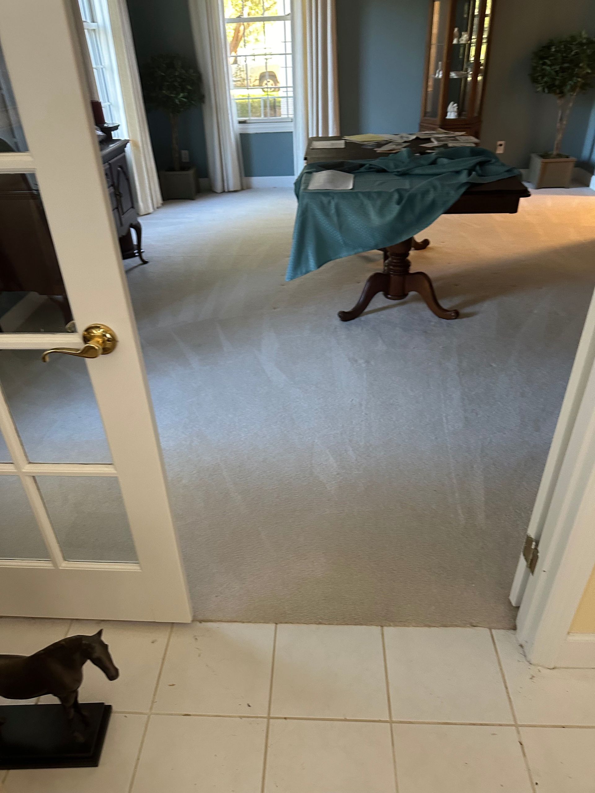 A living room with a table and a statue of a horse