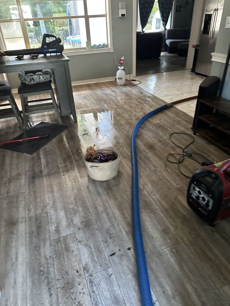 A vacuum cleaner is sitting on a wooden floor in a living room.