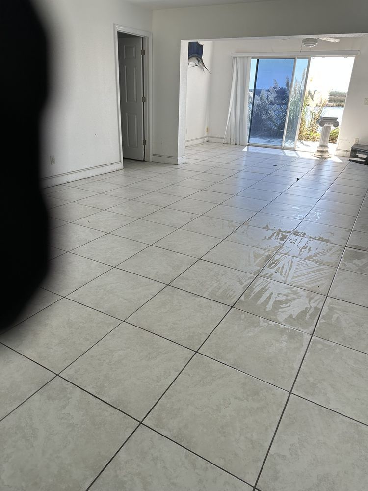 A large empty room with a tiled floor and a sliding glass door.