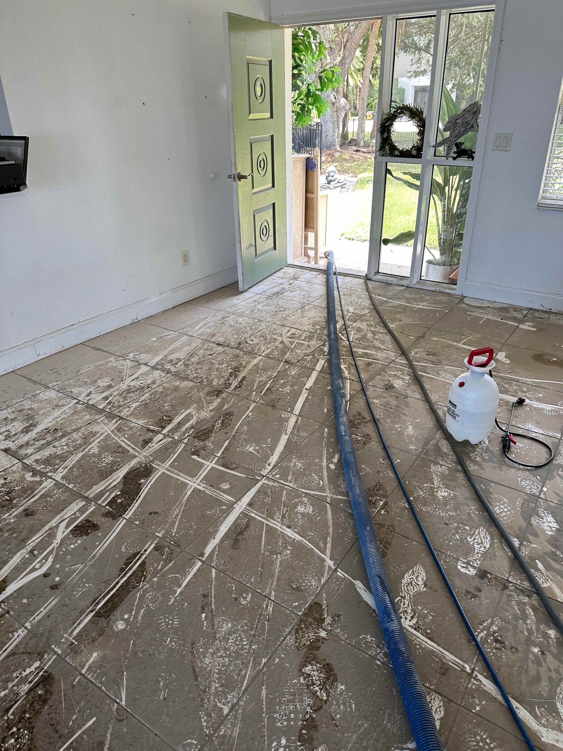 A room with a vacuum cleaner and a hose on the floor.