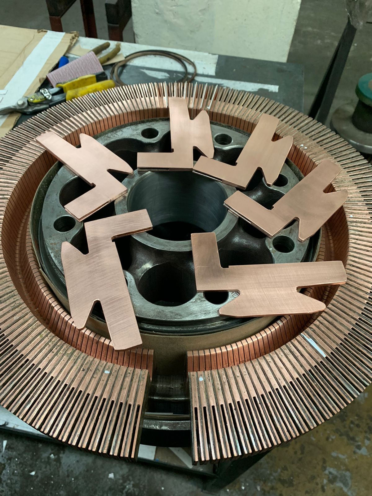 Bobina del estator del motor de color cobre con varios recortes de cartón como espaciadores en la parte superior