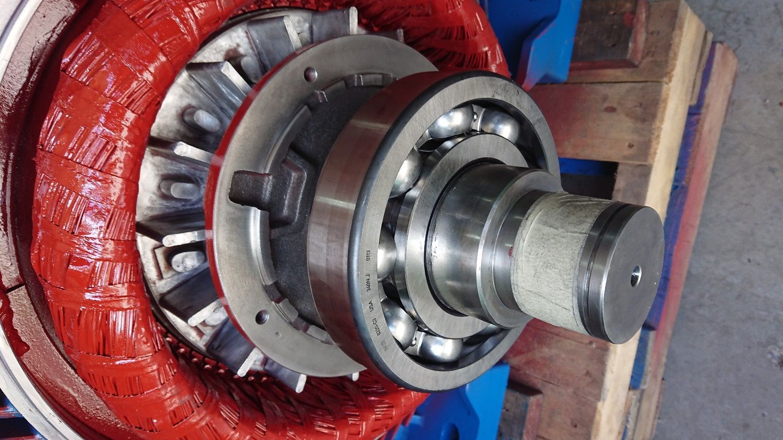 Primer plano de un gran conjunto de cojinetes metálicos industriales envuelto en plástico rojo.
