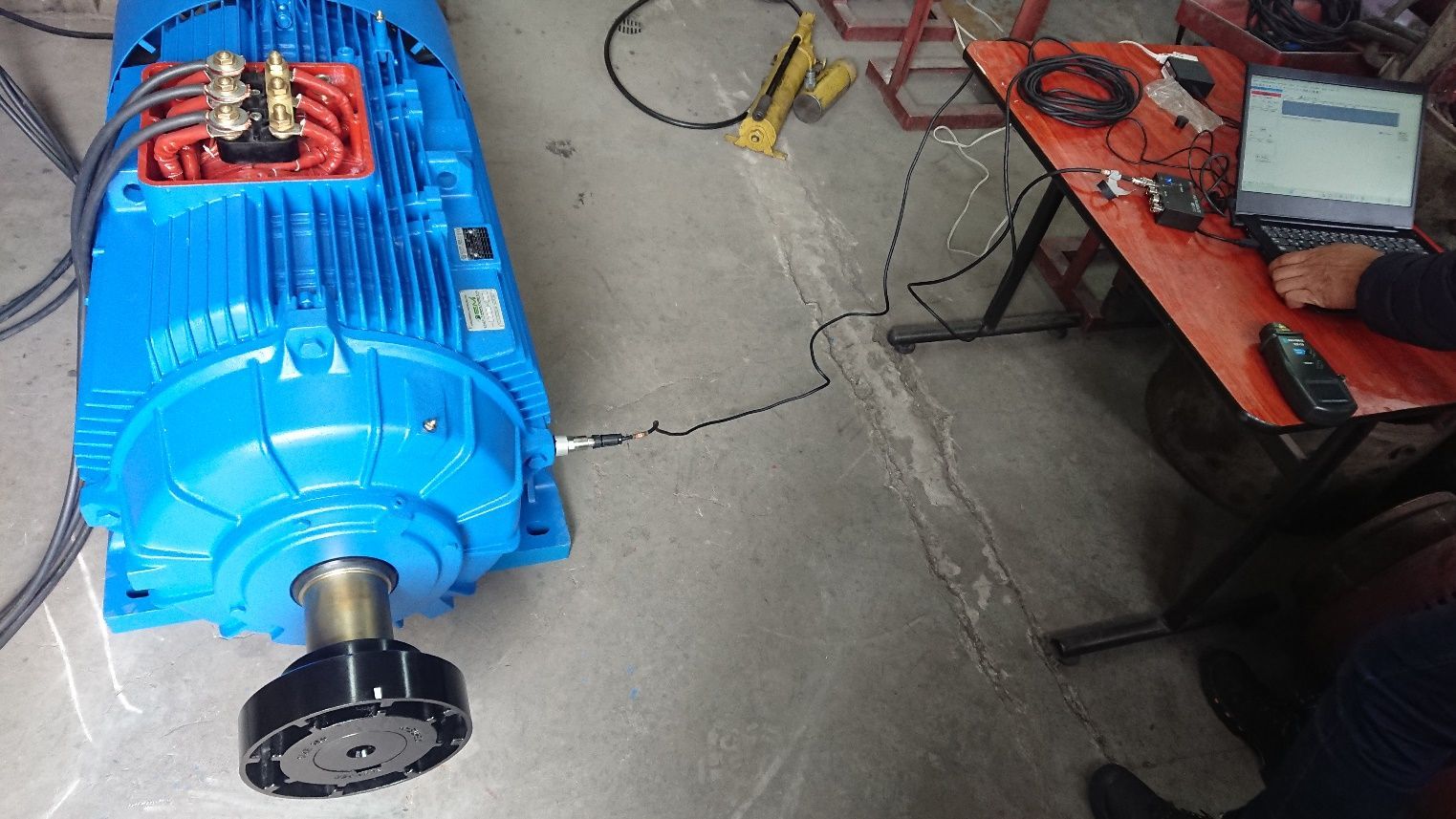 Un motor industrial azul sobre un suelo de hormigón