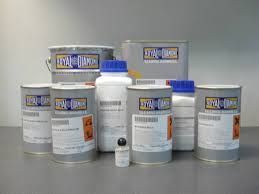 Cubos y botellas de plástico blanco de diversos colores con tapas azules, dispuestos sobre una superficie gris.
