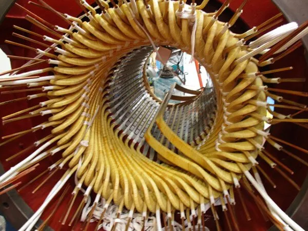 Primer plano de un rotor industrial en espiral de color amarillo y plateado con radios radiales dentro de una carcasa roja.