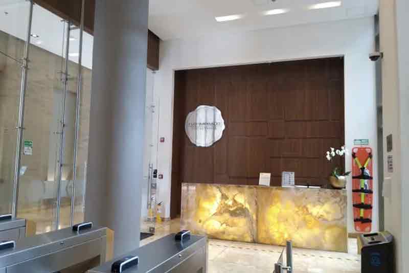El vestíbulo el edificio Flormorado empresarial con un gran mostrador de madera y un reloj en la pared.
