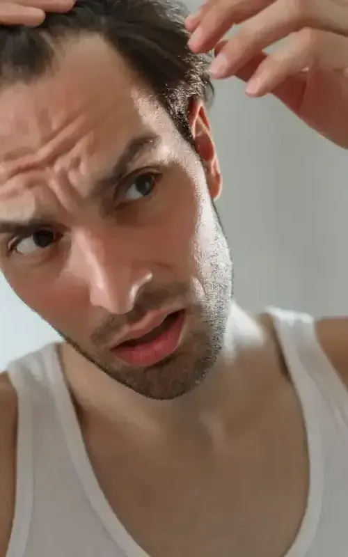 a man with a beard is laying down and looking at the camera .