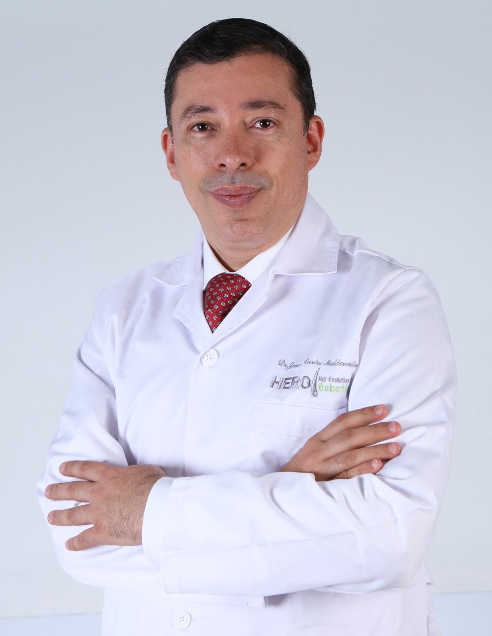 a man wearing a white lab coat and a red tie