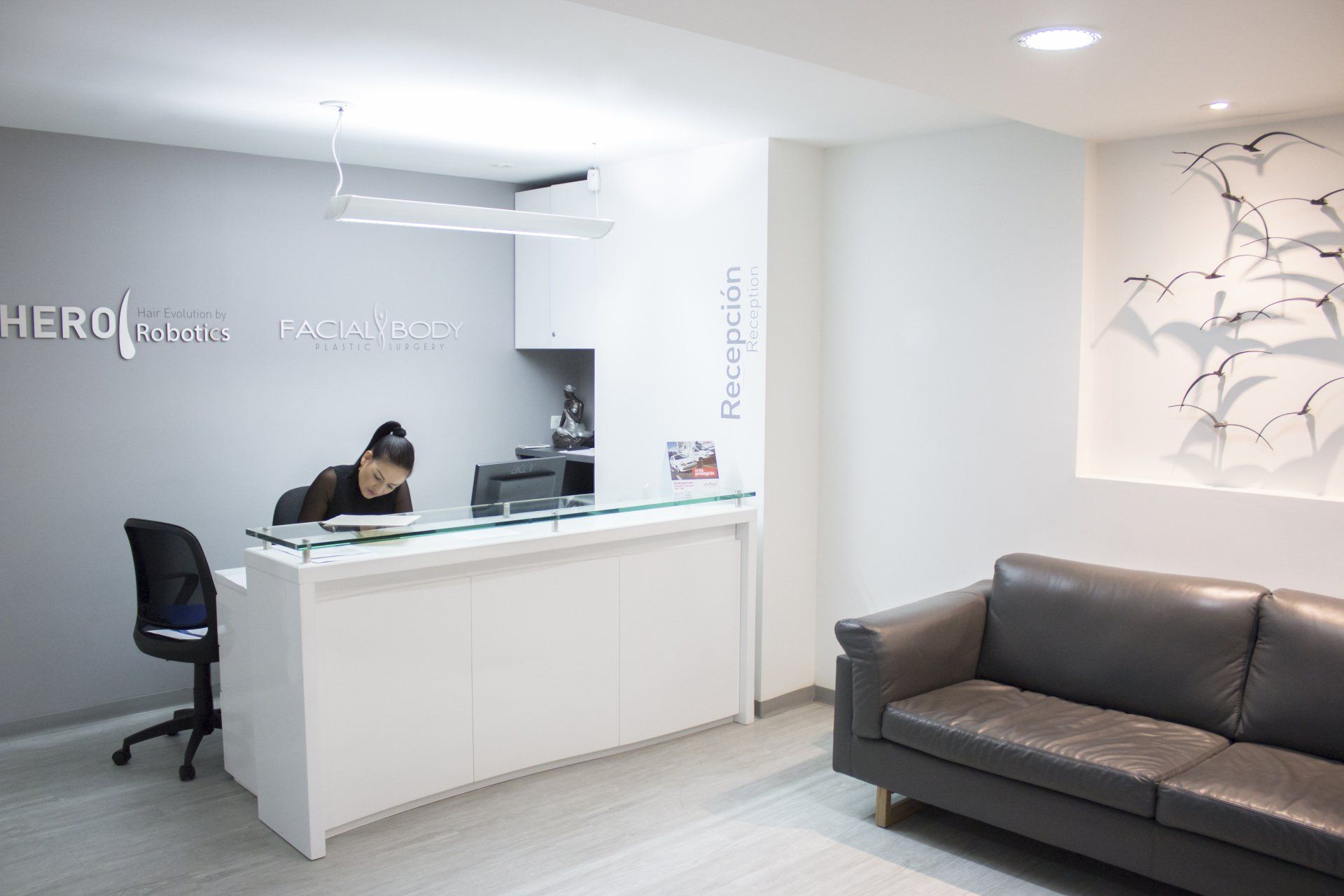 Dental office interior with white desk, black chair, window, and medical equipment.