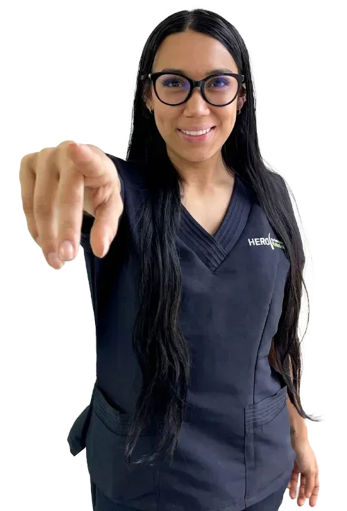 a woman wearing glasses and a scrub top is pointing at the camera .