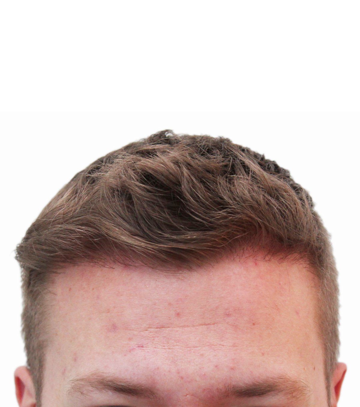 Close-up of a person's head, brown hair styled upward, fair skin.