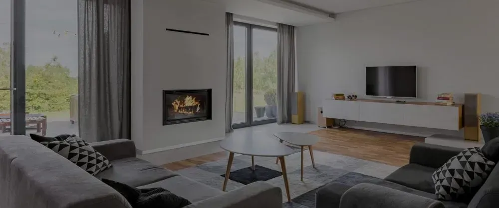 Living room with fireplace, sofas, large windows and TV cabinet.