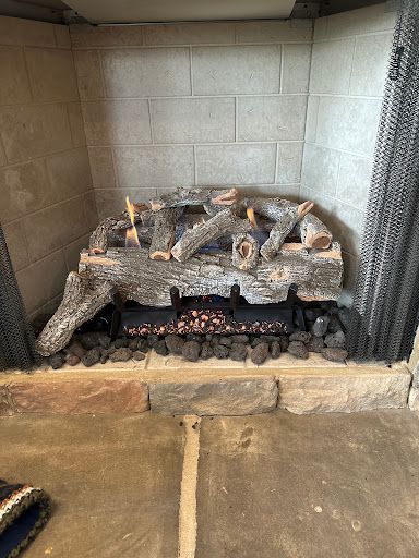 Two crossed swords above a fireplace with festive lights and decorations.