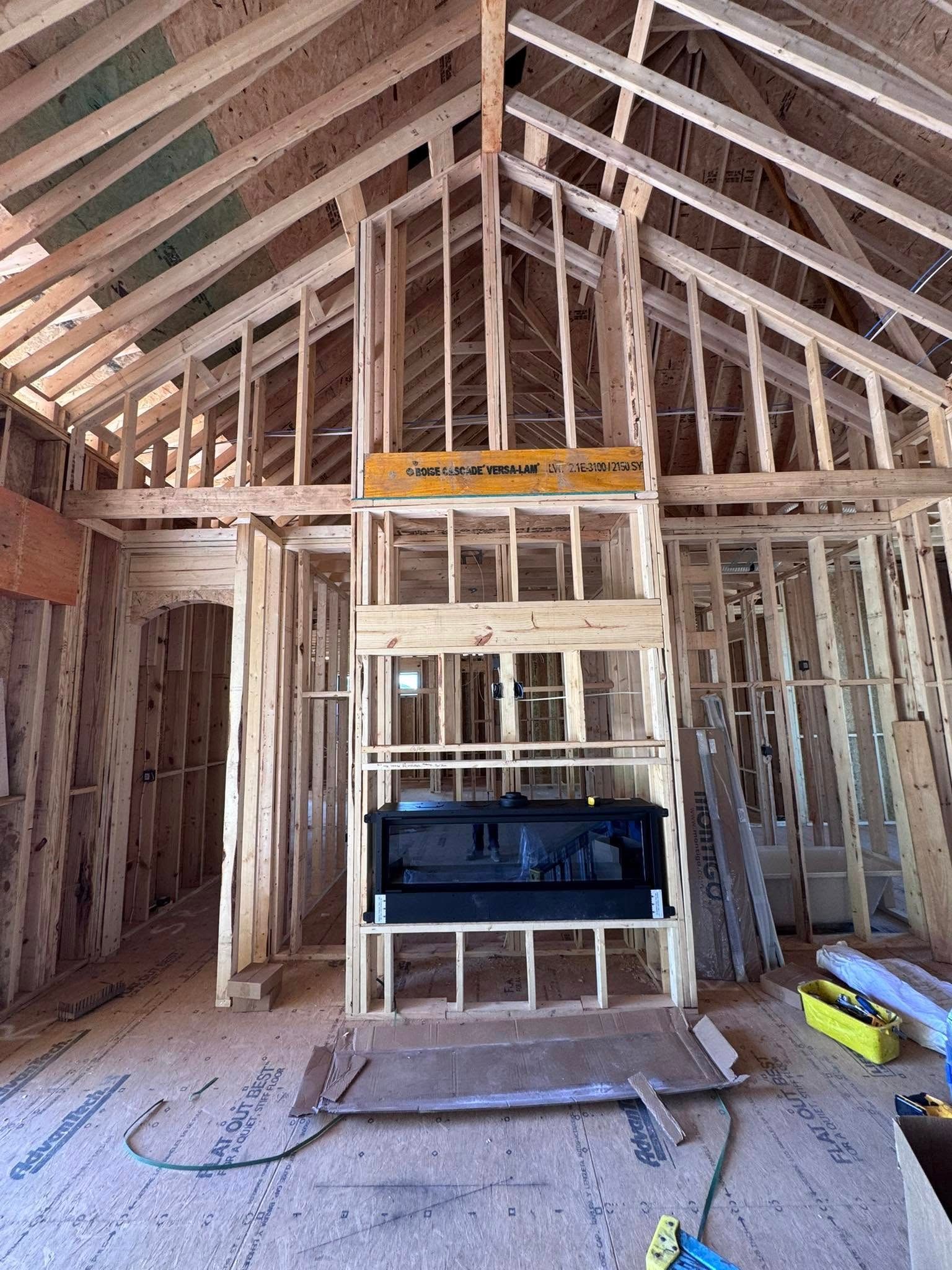 Wooden house framing with a fireplace, under construction.
