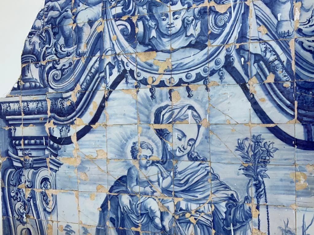 Uma pintura azul e branca de uma mulher segurando um bebê