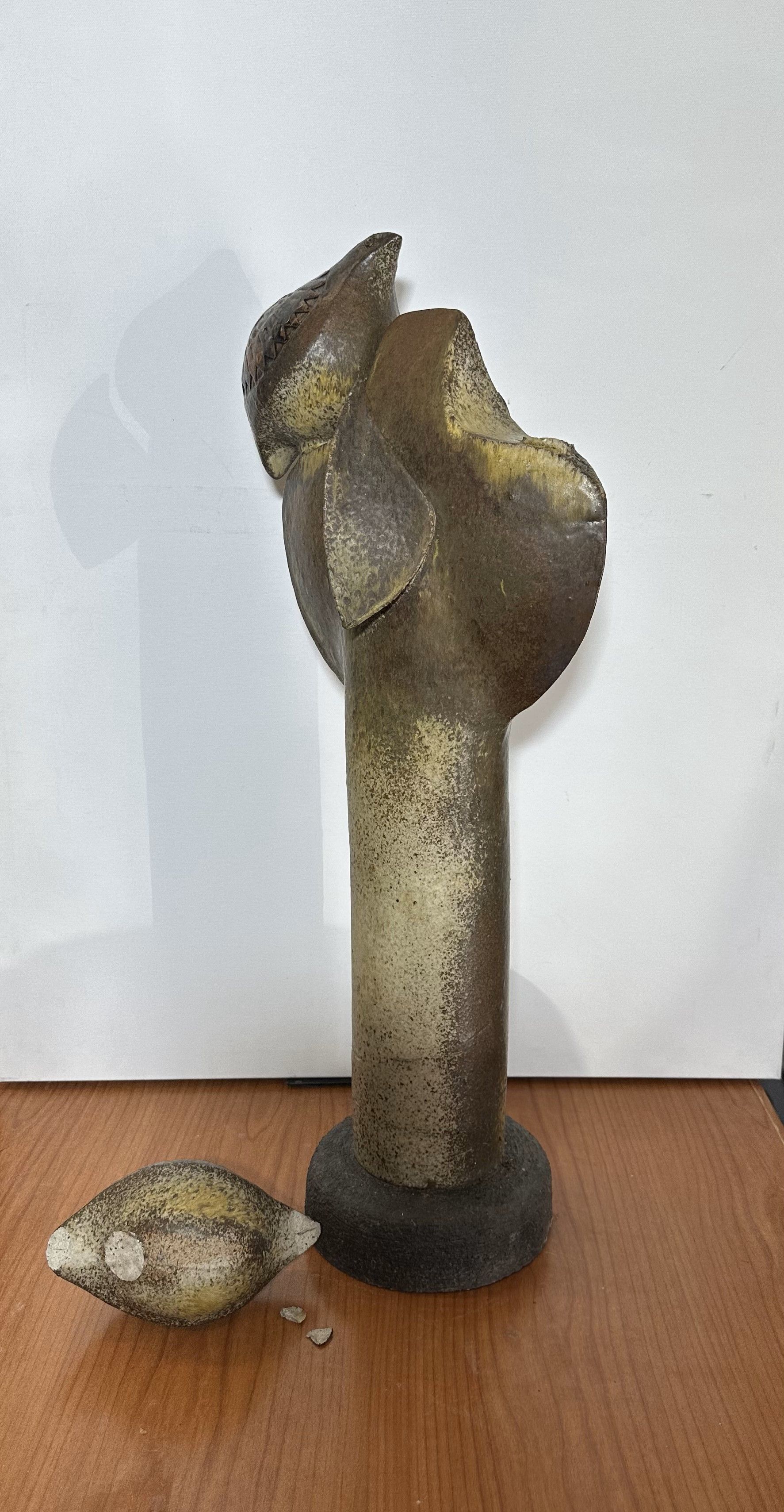 Uma estátua de um pássaro e uma tartaruga estão sobre uma mesa de madeira.